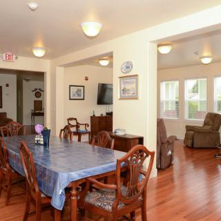 A cozy dining and living area with wooden flooring and classic furniture.