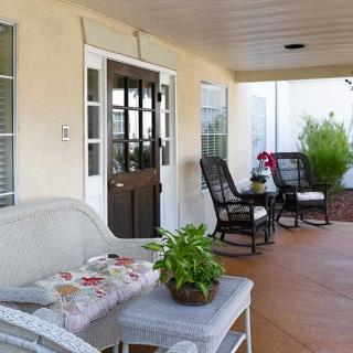 A cozy porch with comfortable seating and decorative plants.