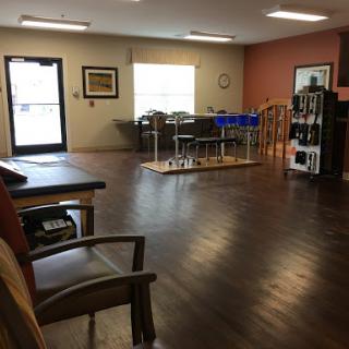 A spacious waiting area with wooden flooring and ample natural light.