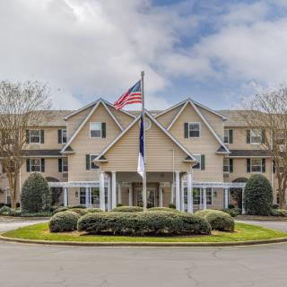 A residential building with flags flying out front and neatly maintained landscaping.