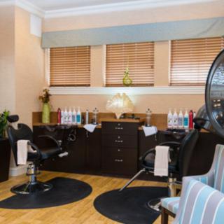 A cozy hair salon interior with styling chairs and beauty products.