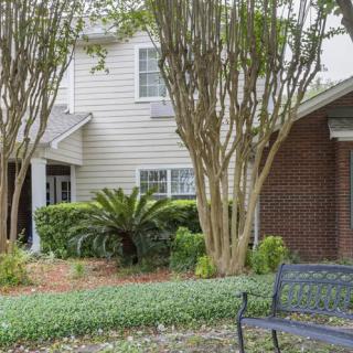 A cozy residential house with well-maintained garden and a bench for relaxation.