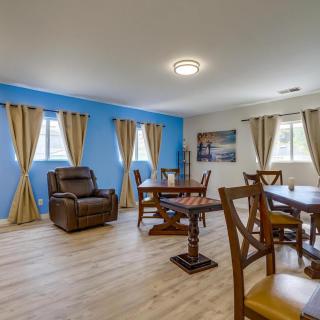 A spacious living room with a blue accent wall, featuring a recliner and dining table set on wooden flooring.
