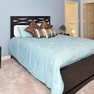 A cozy bedroom with a neatly made bed and stylish pillows.