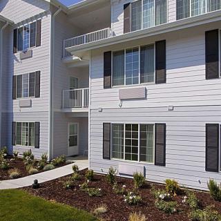 Modern apartment building with balconies and landscaped garden.