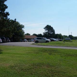 A view of a parking lot surrounded by greenery on a sunny day.