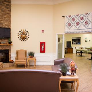 A cozy lobby area with comfortable seating, decorative wall art, and a fire safety fixture.