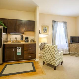 A cozy apartment interior featuring a compact kitchen and a comfortable living area.