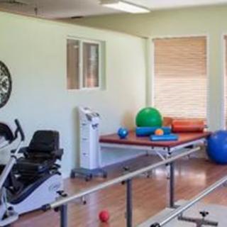 A physical therapy room equipped with various exercise equipment and tools for rehabilitation.