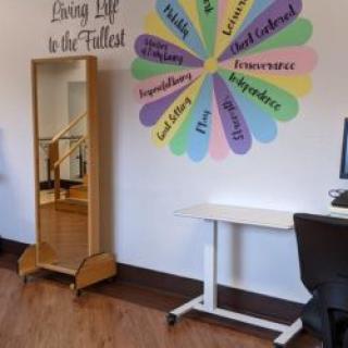 A motivational office space with colorful wall decor and a mirror.