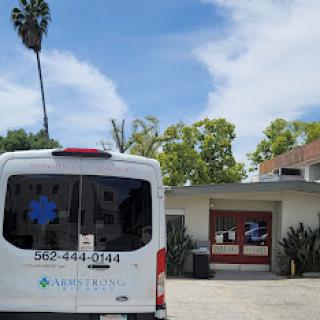 A healthcare van parked outside a building under a clear blue sky.