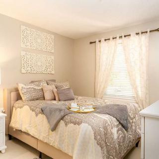 A cozy bedroom featuring neutral colors, decorative pillows, and elegant bedding.