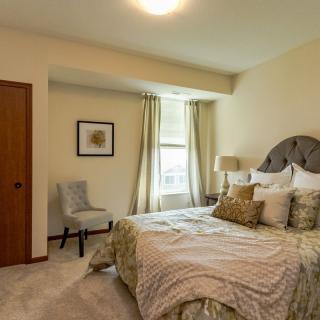 A cozy bedroom interior with a well-decorated bed and soft lighting.