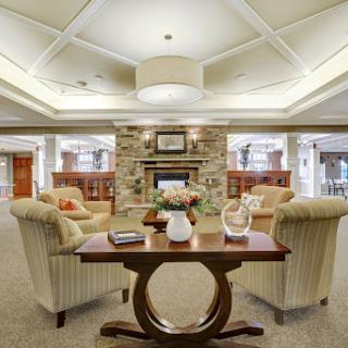 A cozy and modern lounge area featuring comfortable seating and a warm fireplace.