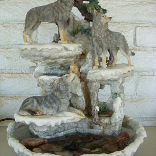 A decorative wolf-themed fountain with multiple wolves on a rocky landscape.