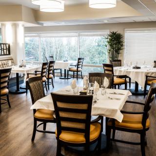 A well-lit restaurant dining room with neatly arranged tables and chairs.
