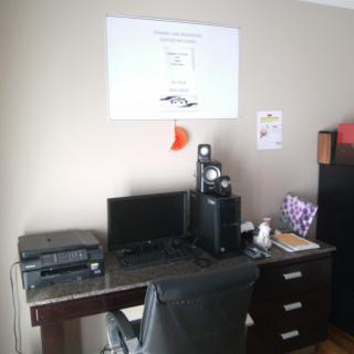 A neatly organized home office setup with a computer desk and equipment.