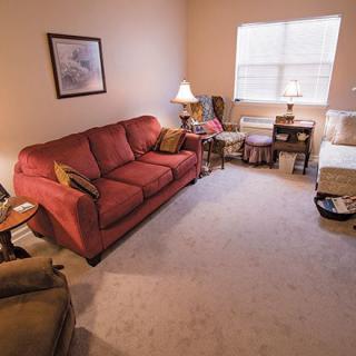 A cozy living room with a red sofa and warm lighting.