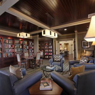 A cozy library space with comfortable seating and a rich wooden interior.