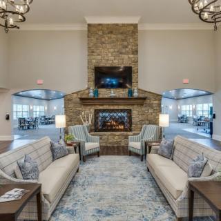 A cozy living room with a stone fireplace and comfortable seating.