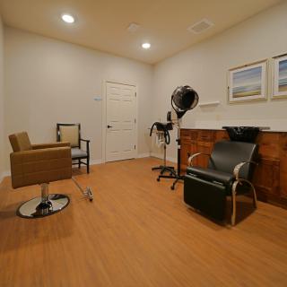 A modern hair salon interior with stylish chairs and a professional hair dryer.