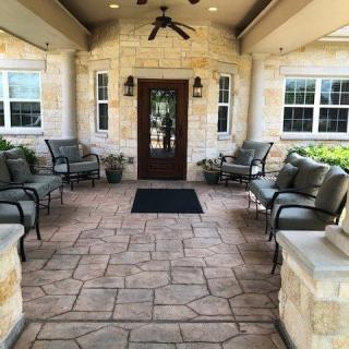 A welcoming entrance with outdoor seating and stone walls.