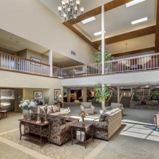A spacious and modern lobby with comfortable seating and a large chandelier.