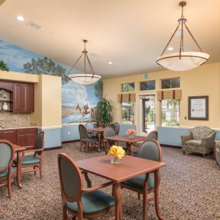 A cozy lounge area with tables, chairs, and decorative lighting.