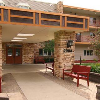 Entrance to a building with stone pillars and outdoor benches.