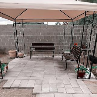 A cozy outdoor seating area with a gazebo and paved floor, perfect for relaxation.