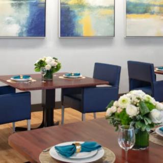 A modern restaurant interior with neatly set tables and contemporary artwork on the walls.