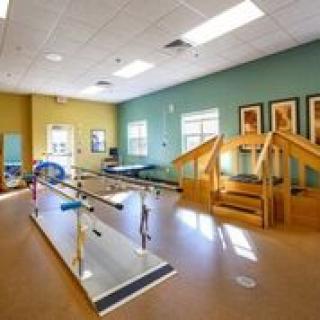 A rehabilitation center room equipped with therapy tools and parallel bars for physical therapy exercises.