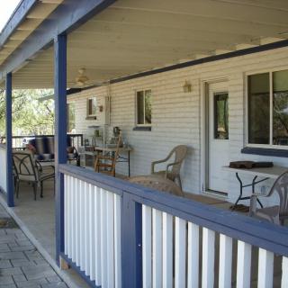 A cozy porch with outdoor seating and a table, perfect for relaxing.