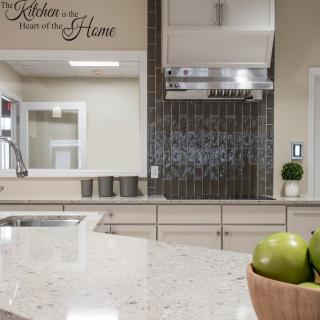 Modern kitchen with a sleek countertop and a wall quote about the heart of the home.