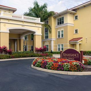 A welcoming entrance to a hotel with vibrant flower beds and elegant architecture.