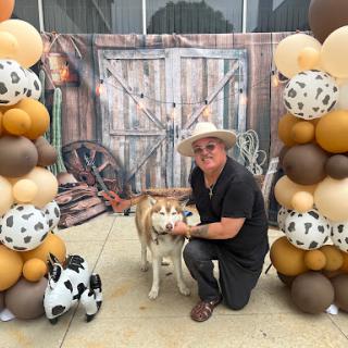 A joyful celebration featuring a guest with a dog amidst festive decorations.