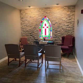 A serene waiting area featuring a beautiful stained glass window and comfortable seating.