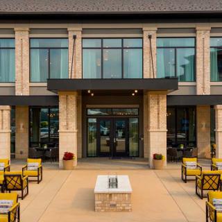Outdoor seating area in front of a modern building entrance.
