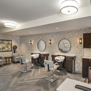A modern and stylish hair salon interior with mirrors and chairs.