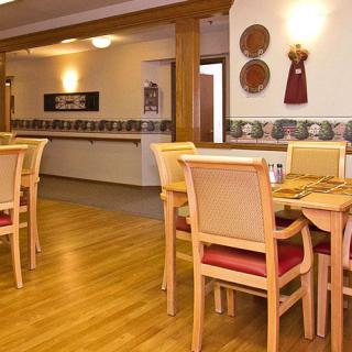 A cozy dining area featuring wooden tables and chairs with decorative elements on the walls.