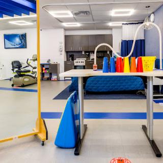 A well-equipped physical therapy room featuring colorful exercise cones and containers, designed for rehabilitation activities.