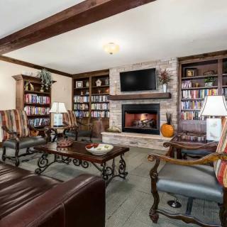 A cozy living room featuring a fireplace, built-in bookshelves, and comfortable seating.