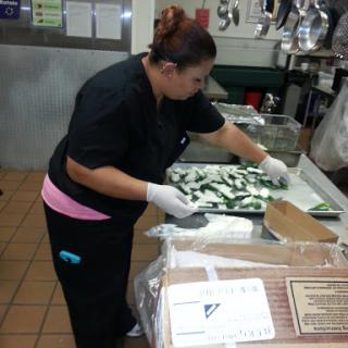 A chef meticulously preparing vegetables in a busy kitchen.