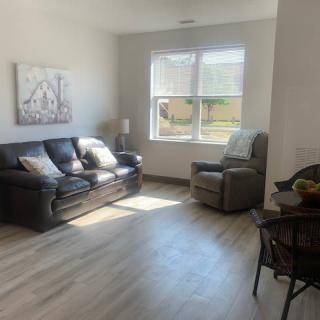 A cozy living room with a sofa and armchair bathed in natural light.