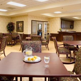 A cozy dining area with neatly arranged tables and chairs, featuring a warm ambiance.