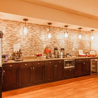 A modern kitchen with wooden cabinets, stylish pendant lighting, and a decorative backsplash.