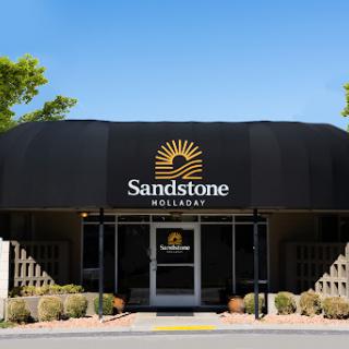 Entrance of the Sandstone resort showcasing modern architecture and clear blue skies.