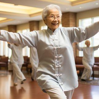 An elderly woman joyfully practices Tai Chi in a group setting indoors.
