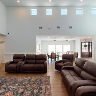 Spacious living room with leather seating and a view into the dining area.