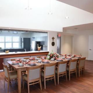 A spacious dining room with a beautifully set table ready for a gathering.